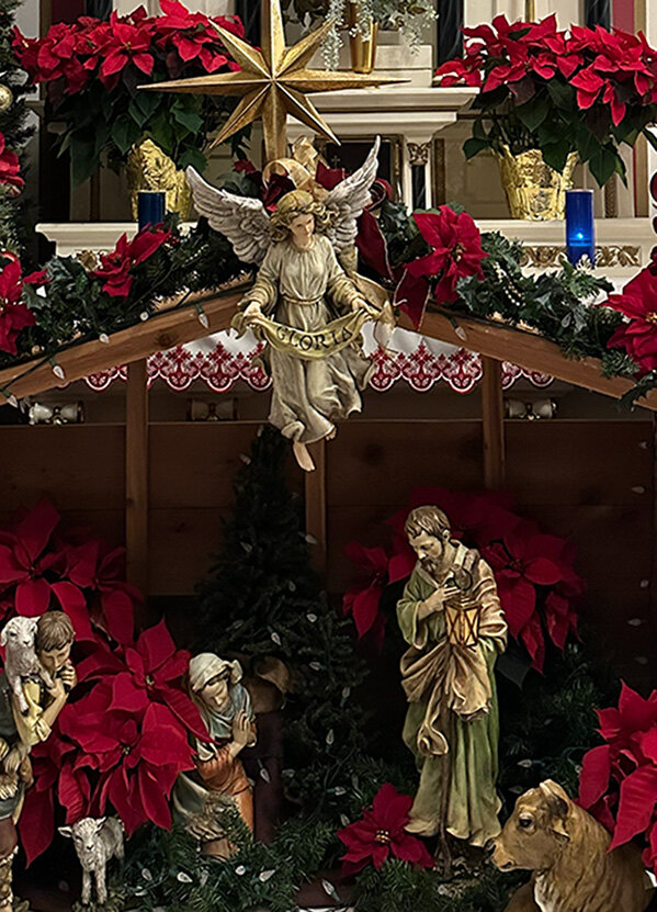 A Nativity scene with Mary, Joseph, an angel, and poinsettias